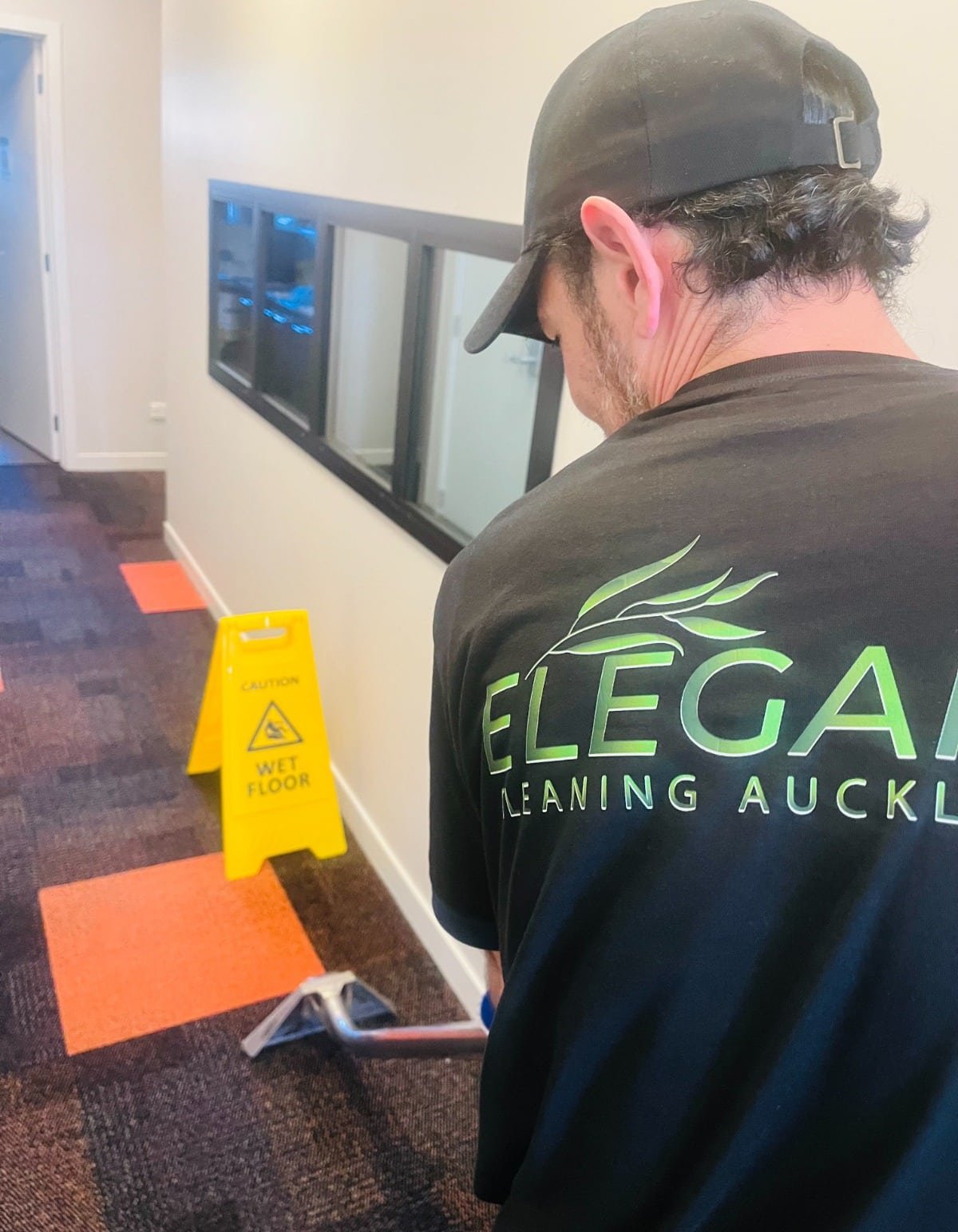 Elegant Clean Team Member cleaning carpet in hallway.